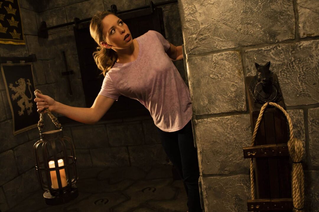 What's Around The Corner? Player holding a lantern and looking around the castle corner.