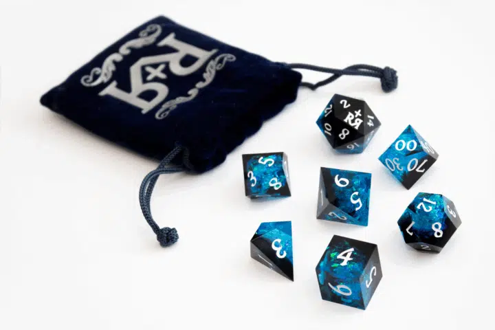 Riddles And Relics Dice With Bag A photograph of a stunning blue and black dice set complete with velvet bag.