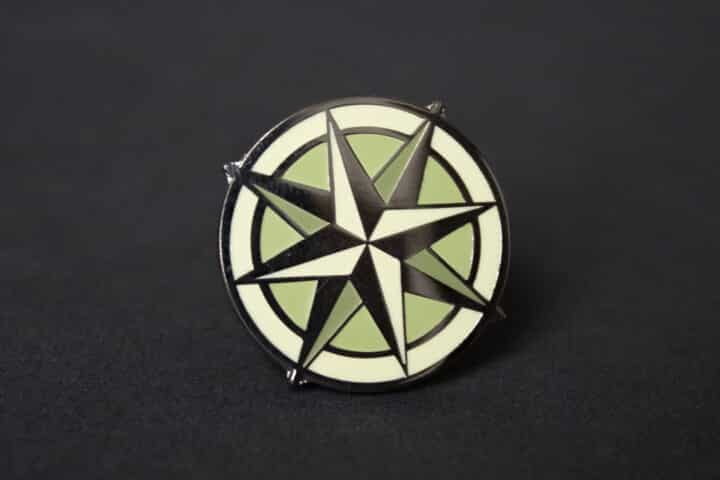Encore Pin A close up of a compass lapel pin.