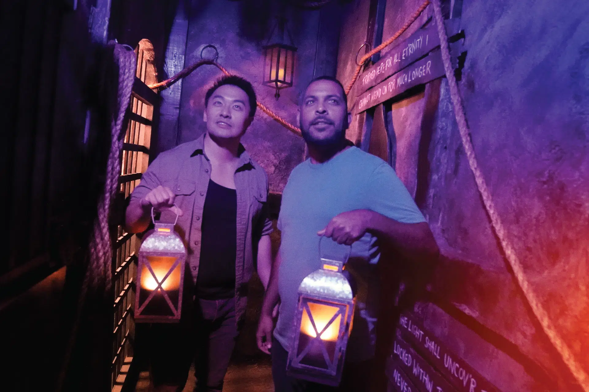 Illuminating The Castle Dungeon Two players cautiously enter the dungeon holding lanterns to guide them.