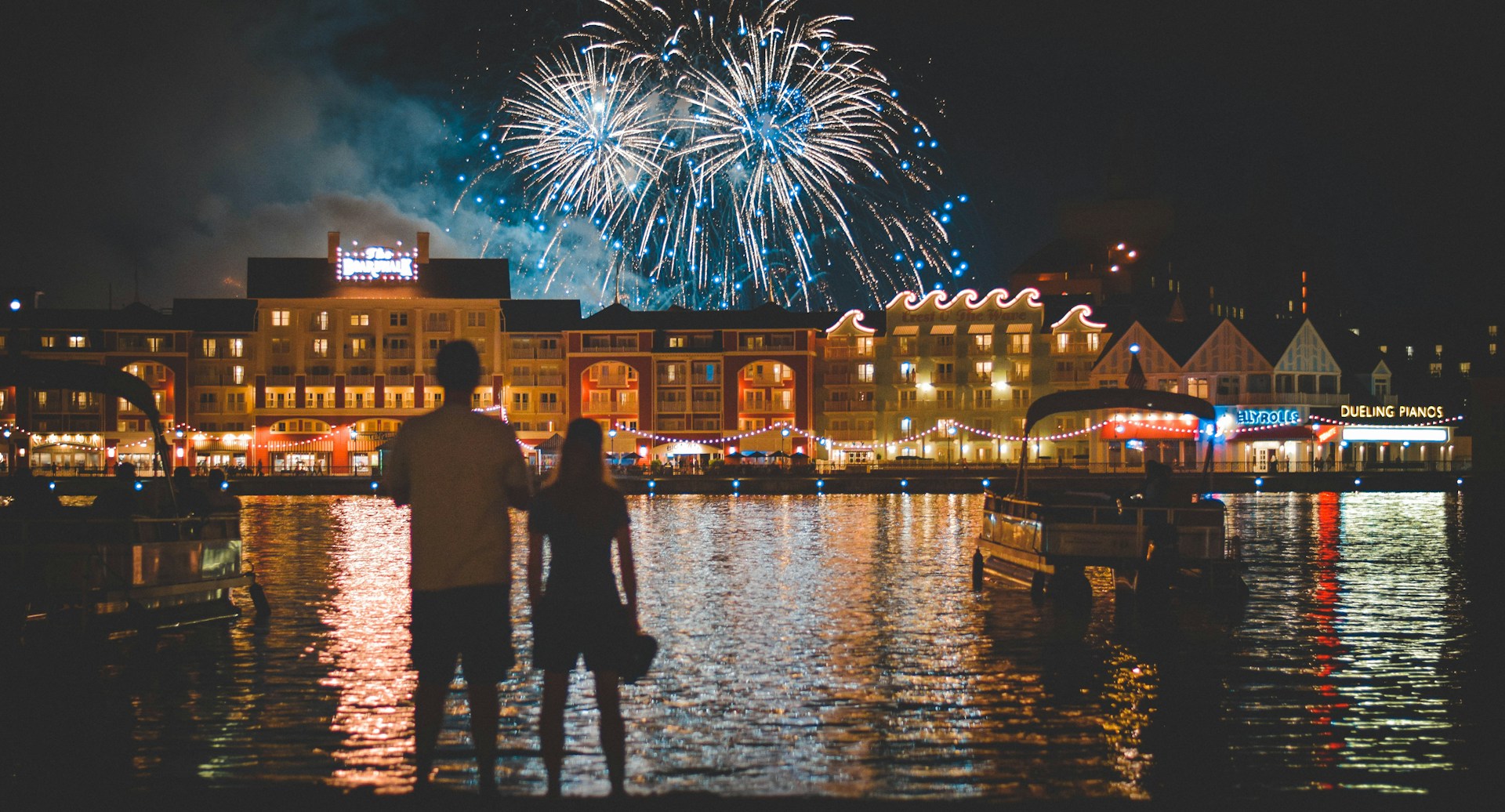 A couple watch fireworks over the boardwalk.