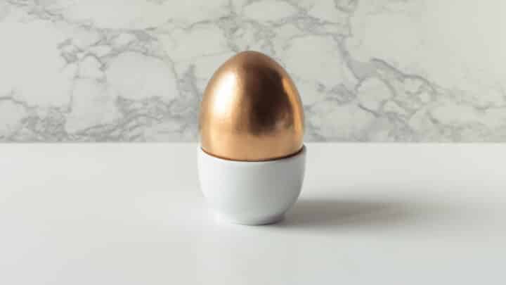 A gold Easter egg on a white table.