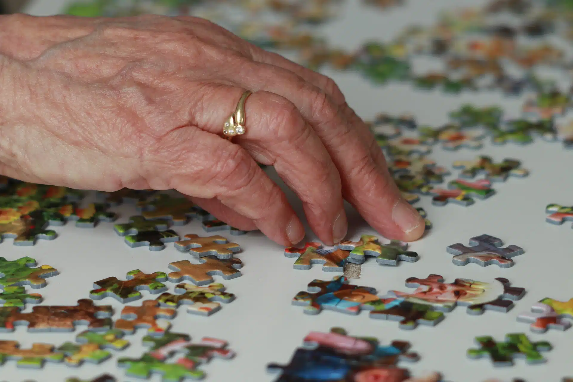 A hand sorts through puzzle pieces to find the right match.