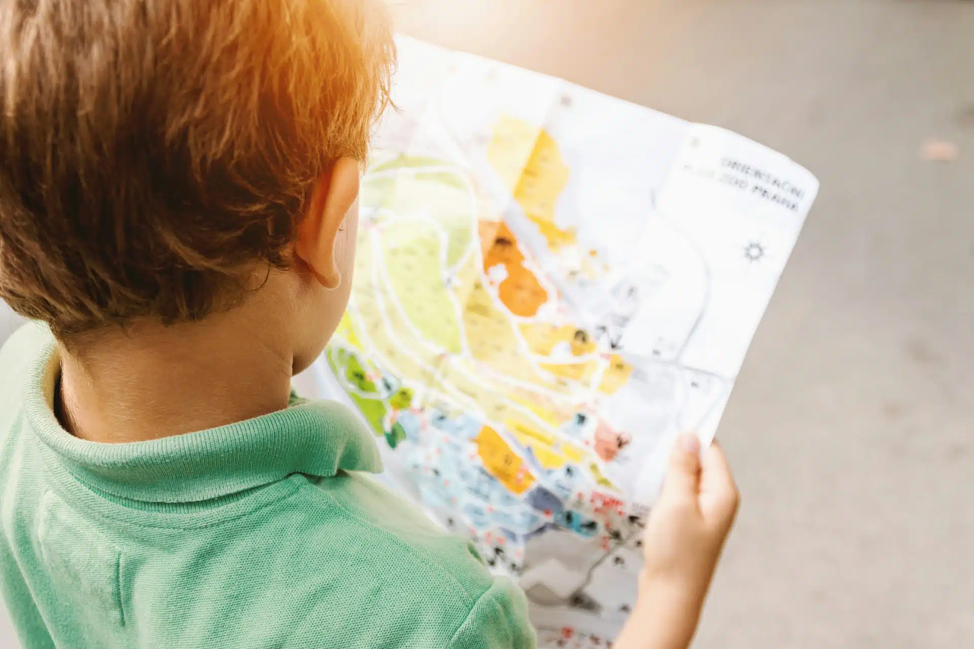 A child holds a colorful map.