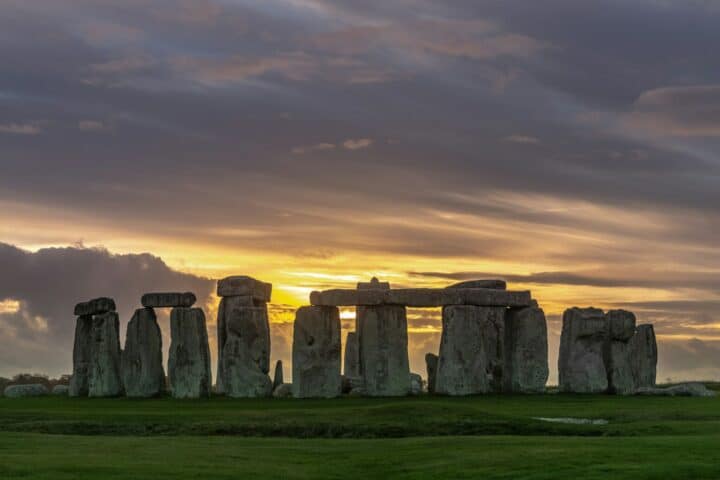 A photograph of the impressive Stonehenge monument at sunset.