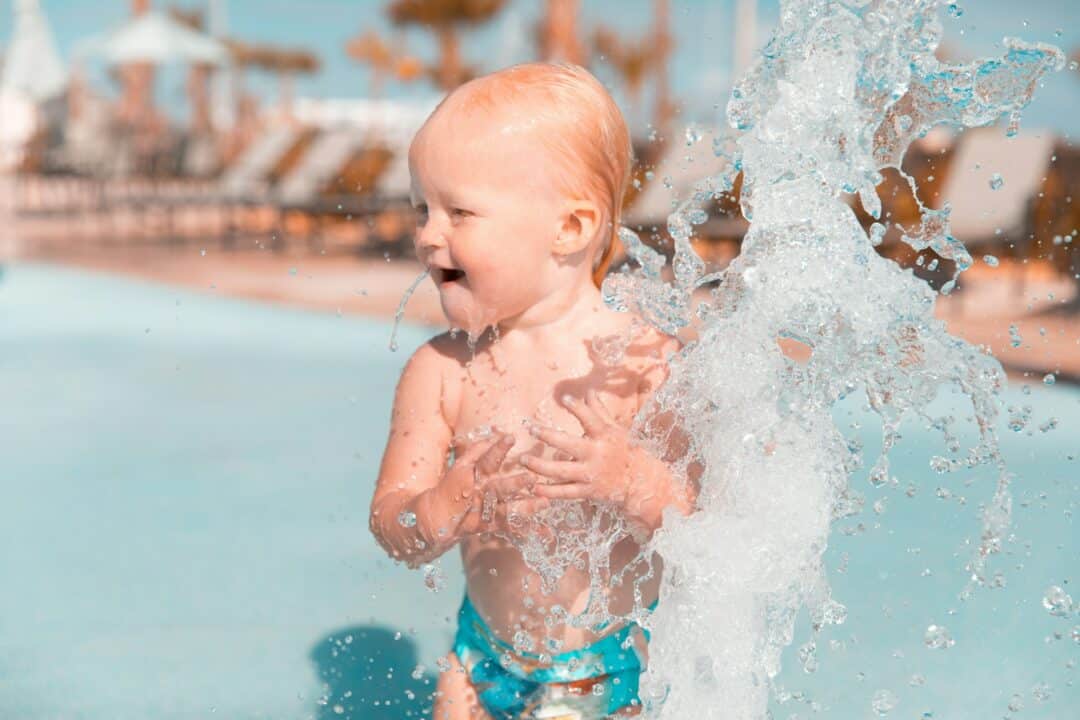 A young child splashes at a waterpark.