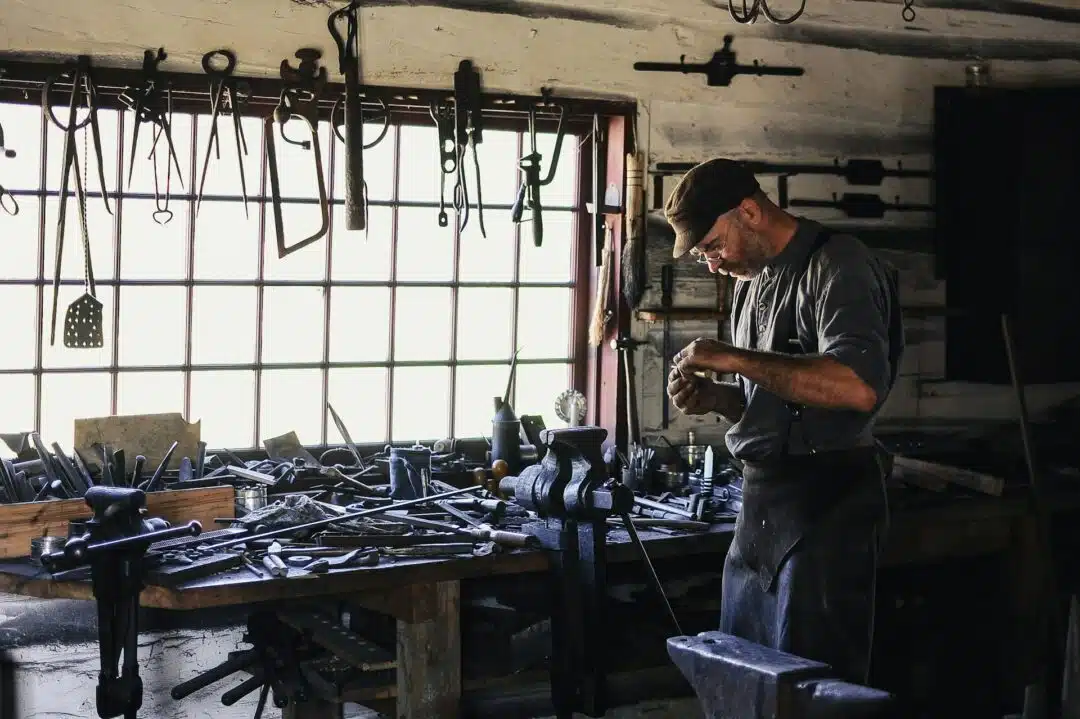 A man surrounded by tools in a workshop.