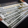 Three escape room bumper sticker sets fanned out.