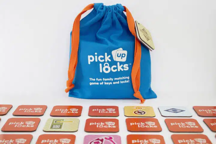 A bag of Pick Up Locks with tiles arranged in a grid in front of it.