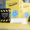 A close-shot photo of Fanatics Gone Bananas, including the rotten box, decks of cards, cards fanned out, and a bunch of bananas on a table.