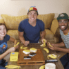 A photo of three people playing Fanatics Gone Bananas in a living room while they smile at the camera.