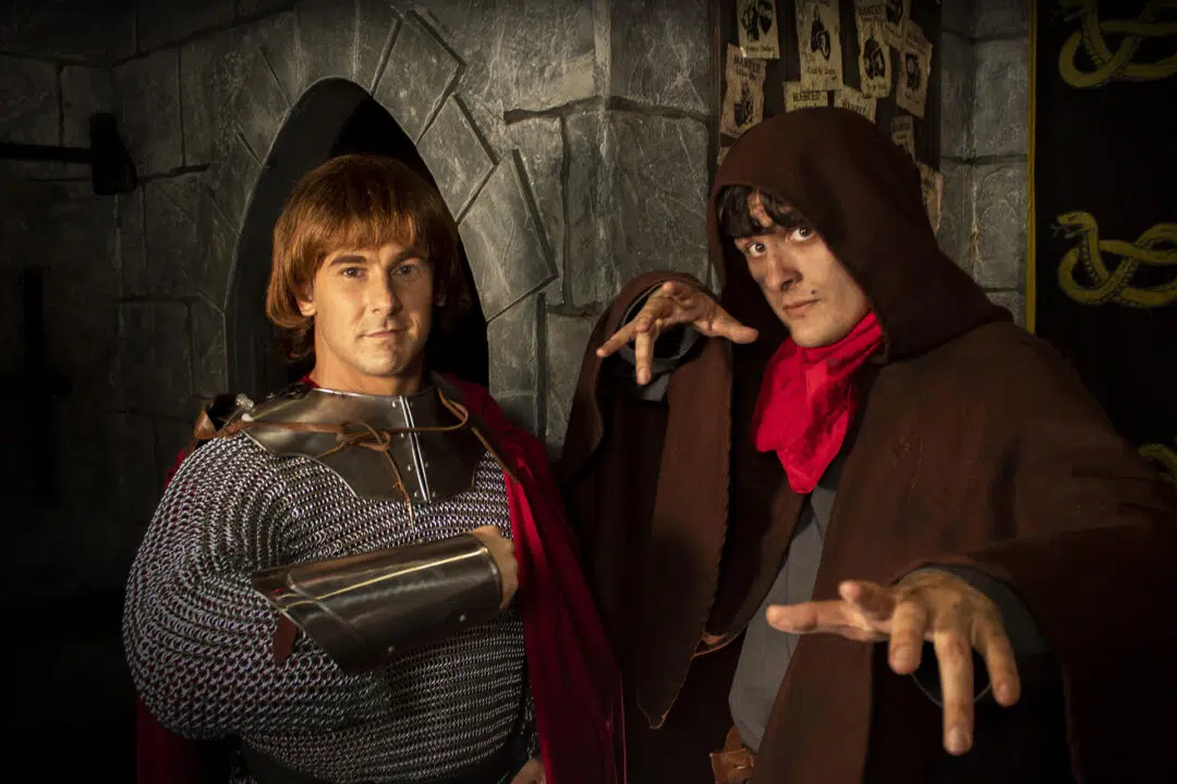 Two medieval knights stand in a castle courtyard.