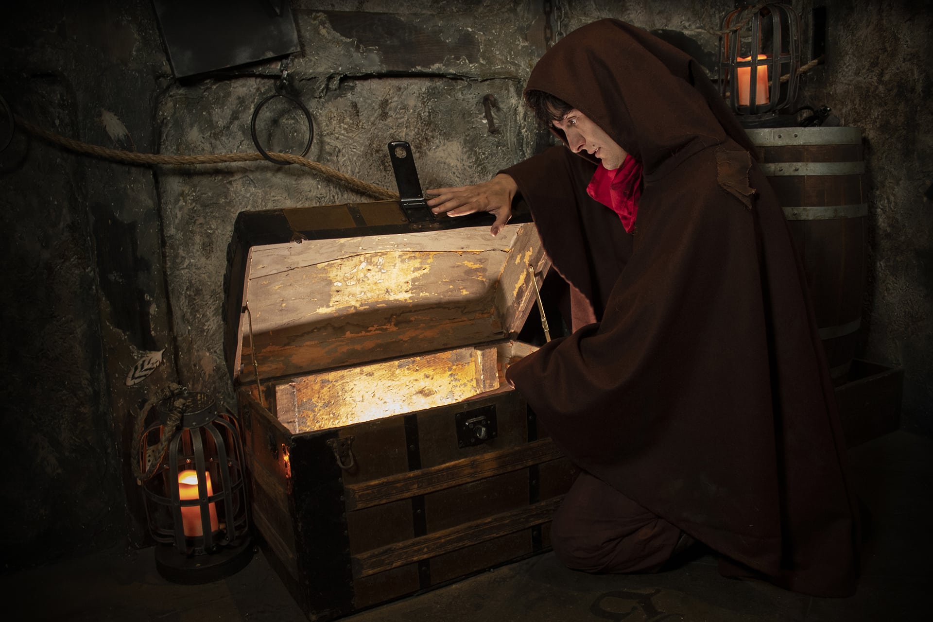 An open chest glows with treasure in a medieval dungeon.
