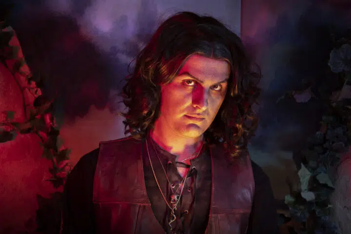 Hades stands ominously, cast in a red light.