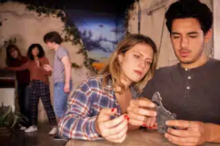 Players solving puzzles inside At Odds With The Gods.