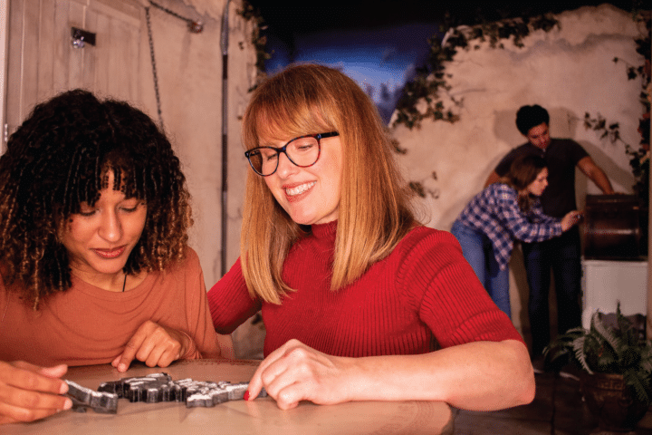 Players solving puzzles inside At Odds With The Gods.