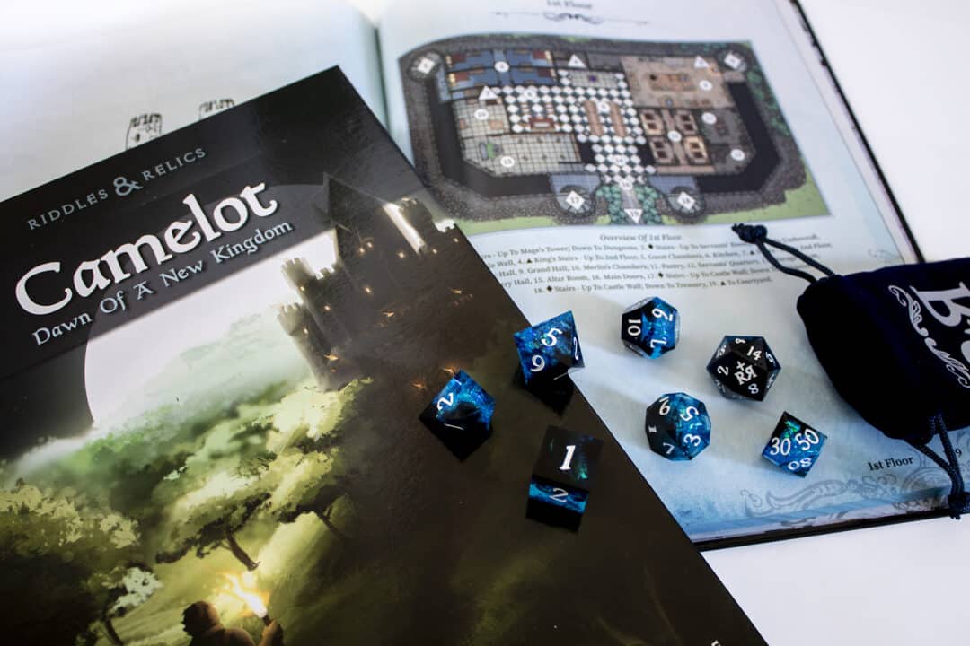 A blue and black dice set, thrown across a blue book page that includes a map.
