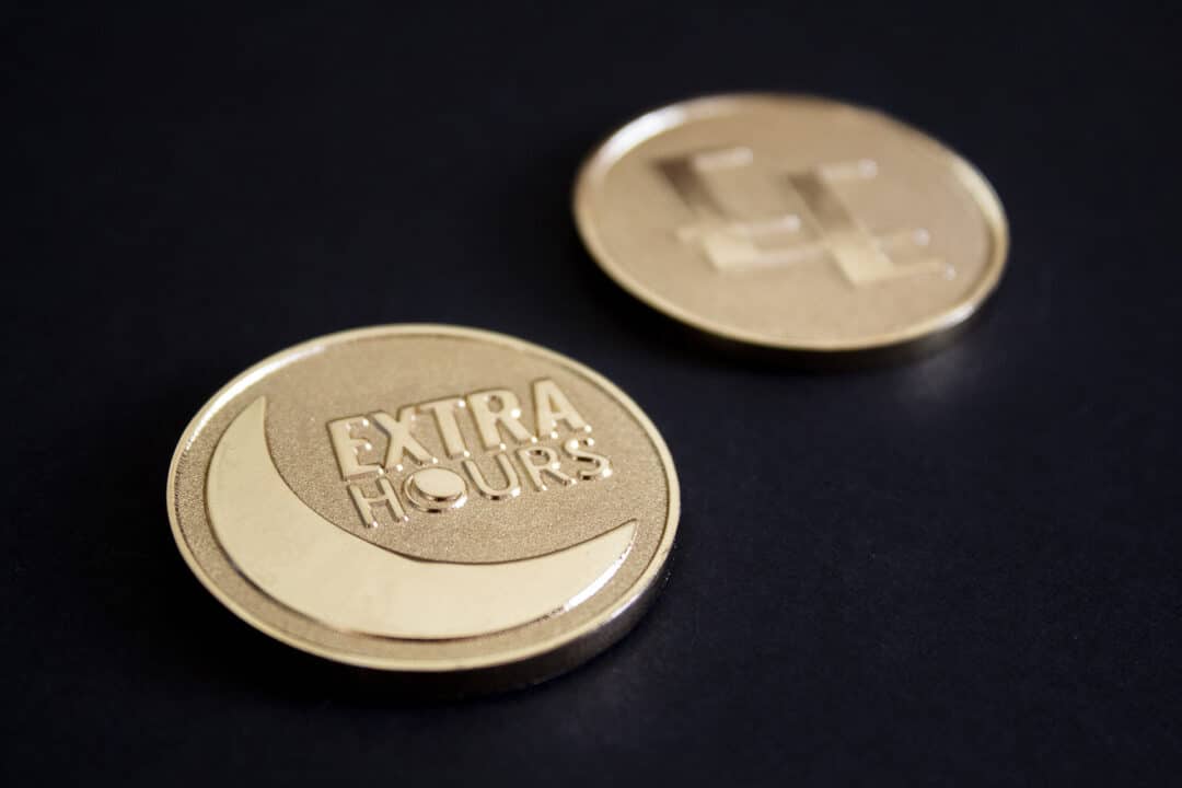 A special edition gold coin with the Extra Hours logo on.