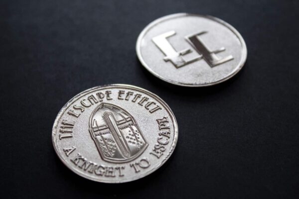 Two coins depicting a knight's helmet and The Escape Effect logo.