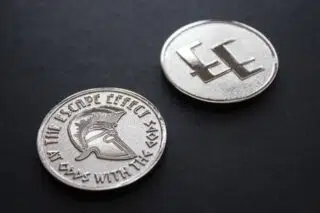 Two coins depicting a Spartan helmet and The Escape Effect logo.