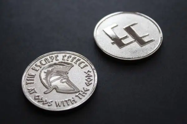 Two coins depicting a Spartan helmet and The Escape Effect logo.