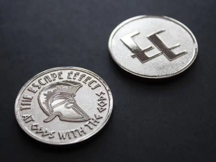 Two coins depicting a Spartan helmet and The Escape Effect logo.