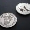 Two coins depicting a deerstalker hat and The Escape Effect logo