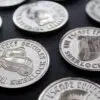 A grouping of coins depicting deerstalker hats