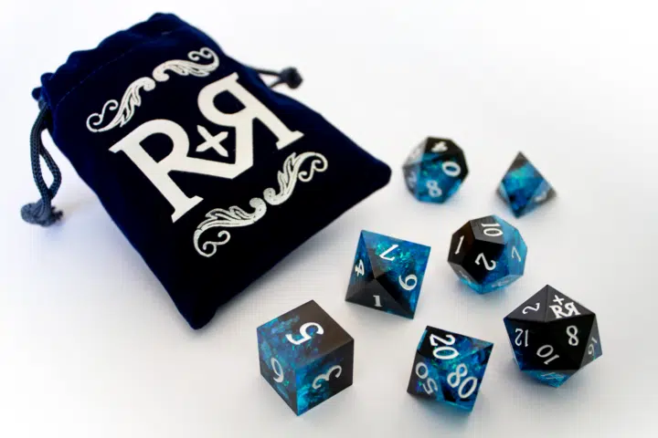 A blue, green, and black dice set with a velvet bag.