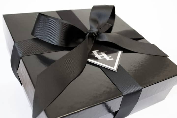A black gift box with a ribbon around it.