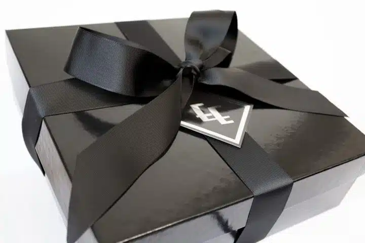 A black gift box with a ribbon around it.