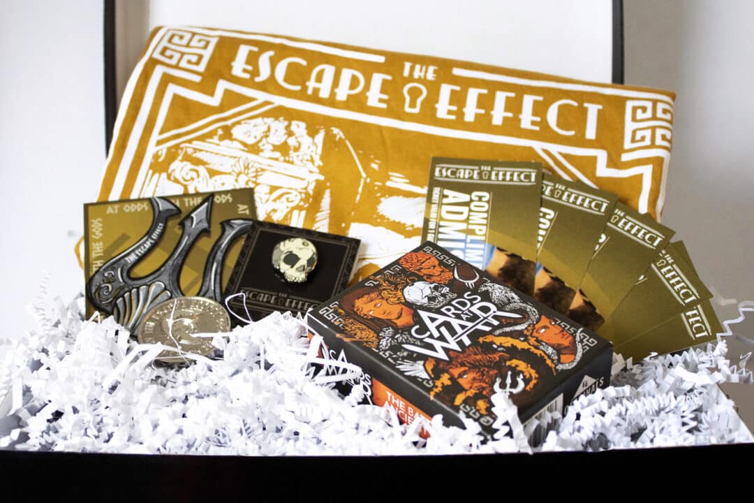 A gift box including tickets, sticker, pin, coin, shirt and card game.