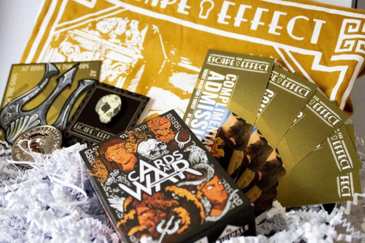 A gift box including tickets, sticker, pin, coin, shirt and card game.