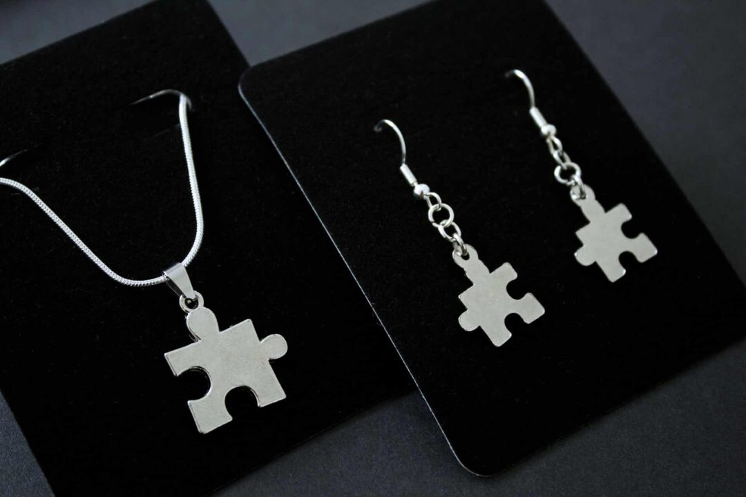 A photograph of puzzle piece earrings and necklace.