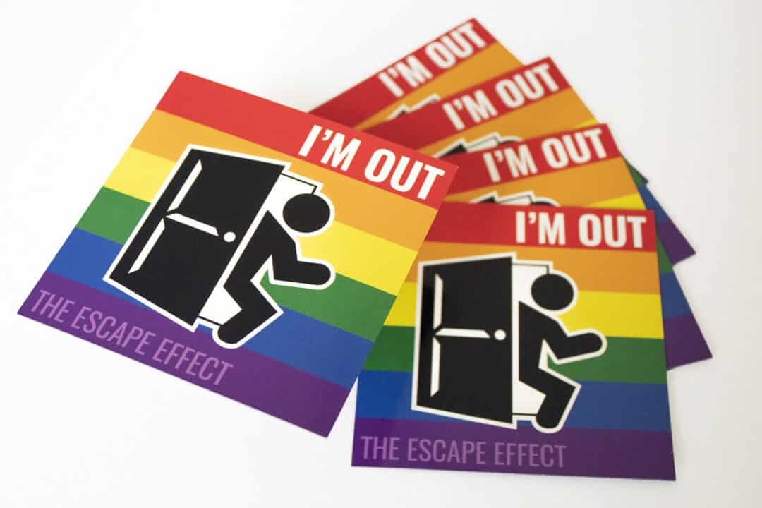 An arrangement of rainbow magnets with a man exiting a door and the phrase 'I'M OUT'.