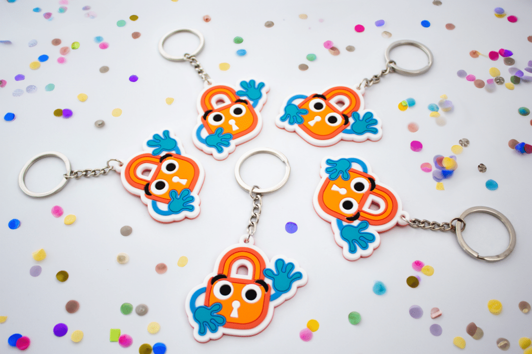 Five Paddy Padlock keychains arranged in a circle with confetti.