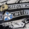 A "The Escape Effect" lanyard with lapel pins, focusing on the shield pin.