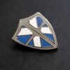 A close up of the "Knight To Escape" shield lapel pin.