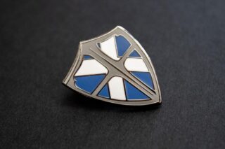 A close up of the "Knight To Escape" shield lapel pin.