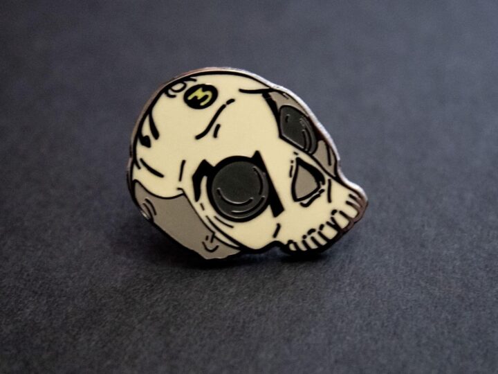 A close up of a skull lapel pin