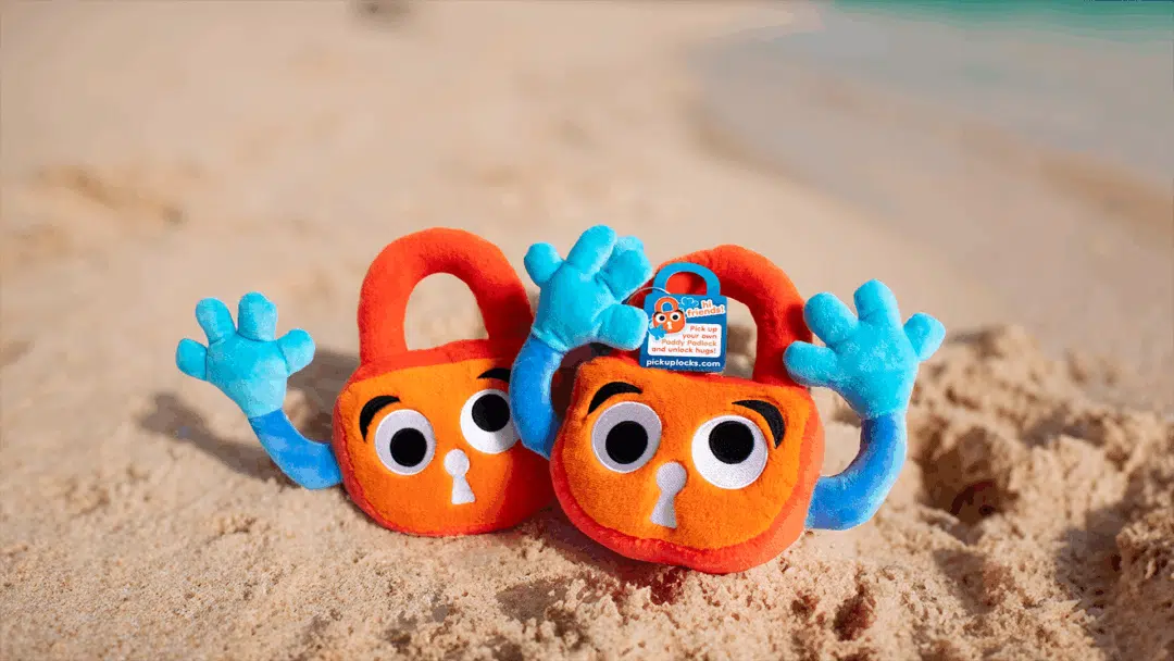 Paddy the padlock and pal, sun themselves on a sandy beach.