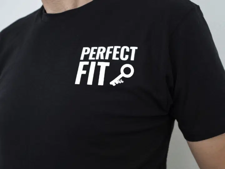A photo showing a shirt with the phrase Perfect Fit, with an image of a key.