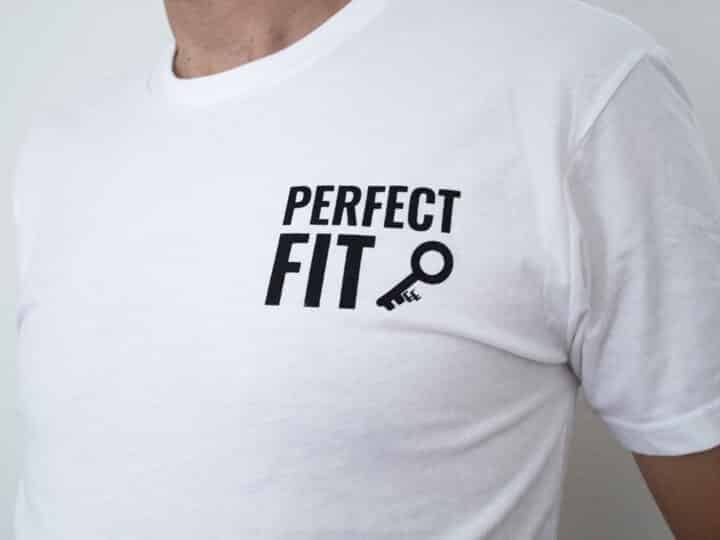 A photo showing a shirt with the phrase Perfect Fit, with an image of a key.