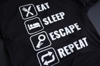 A photo showing a shirt with the phrase Eat, Sleep, Escape, Repeat.