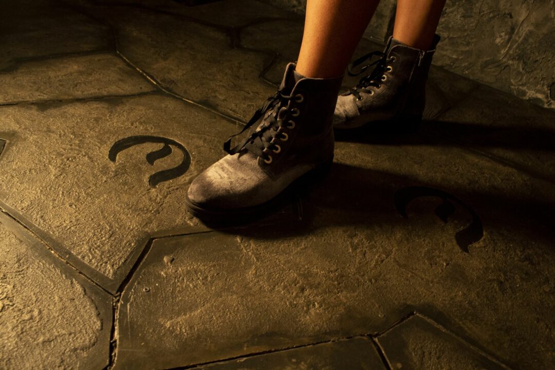 A player is stepping onto an "E" engraved into the courtyard floor.