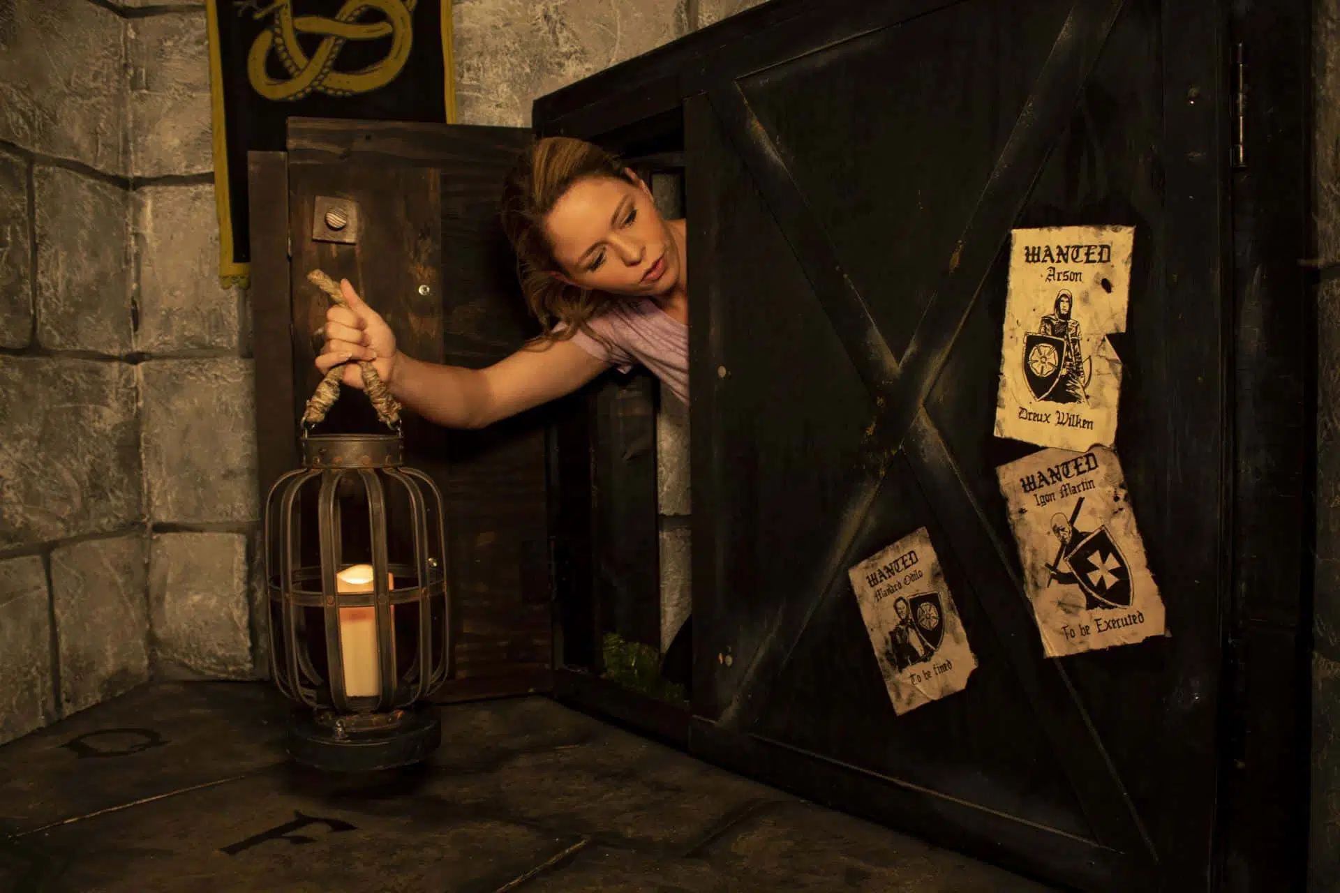 The player is emerging from a pair of small wooden doors and is glancing at a few wanted posters.