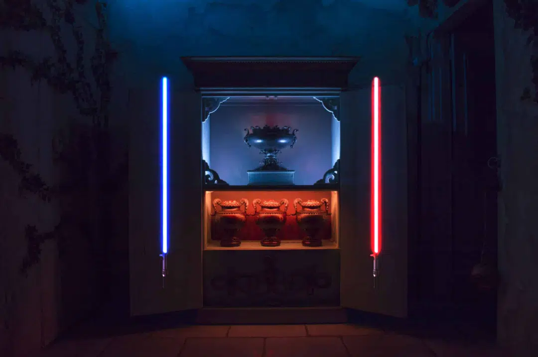 A blue and red lightsaber either side of the ambrosia in At Odds With The Gods.
