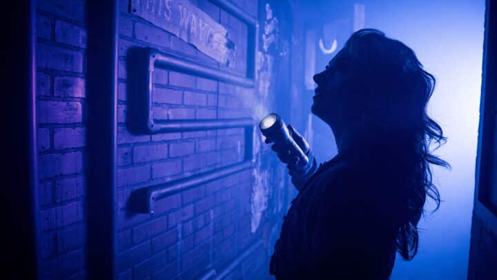 A player in an eerie blue light investigates the abandoned theatre.