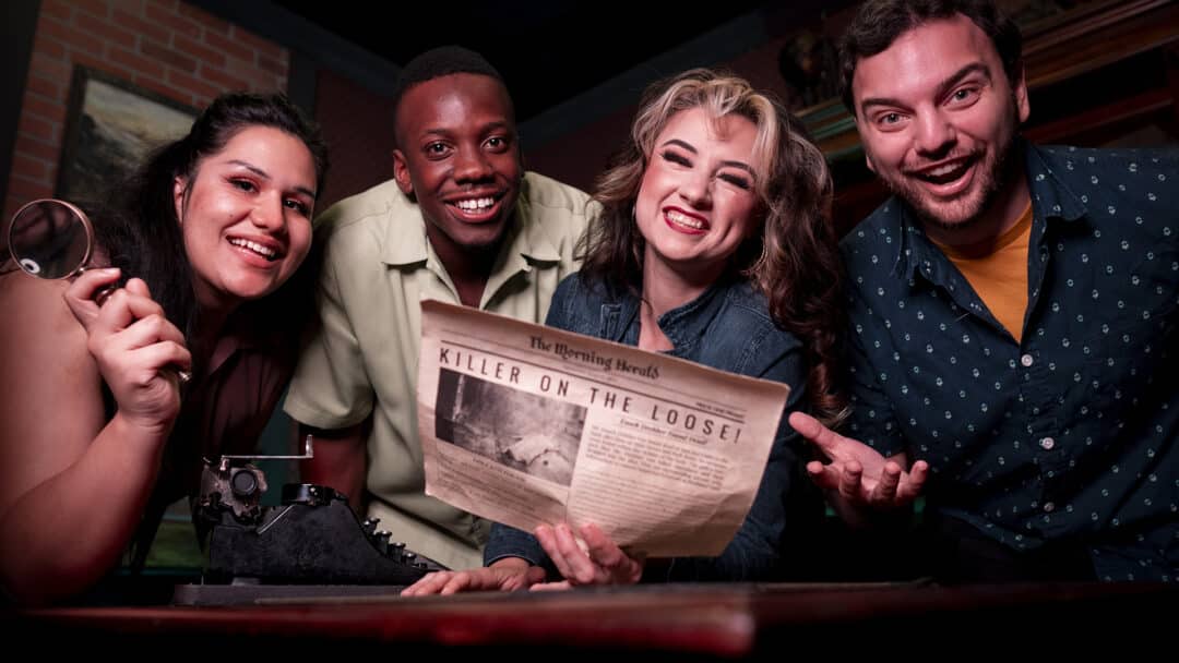 Four friends smile and laugh together as they solve the crime in Sherlock Studies.