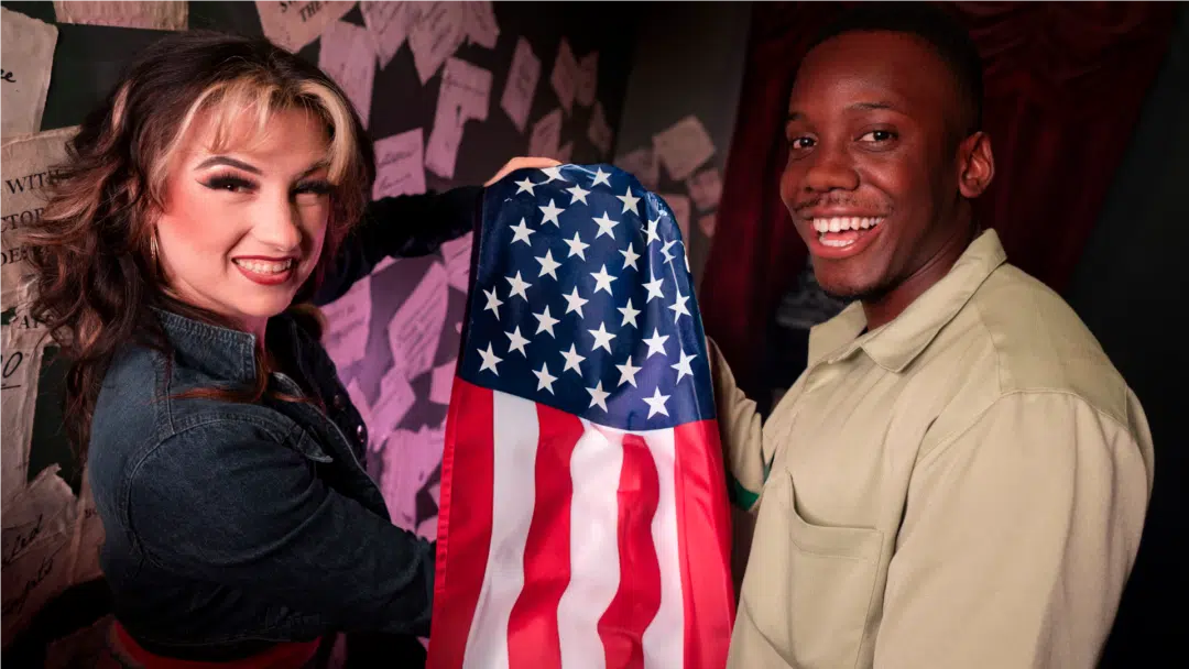 Two players hold up a flag inside an escape room.